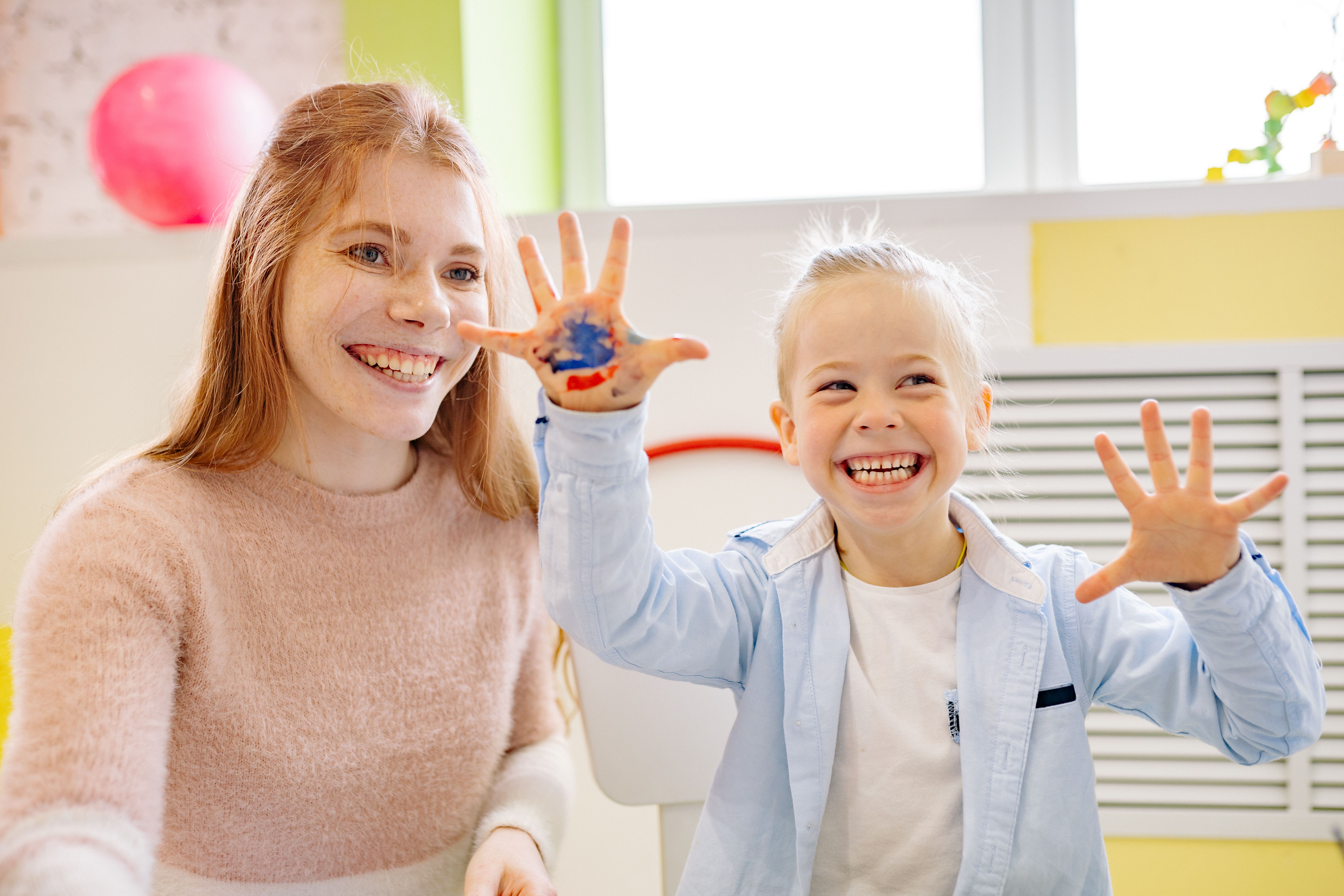 Therapist and young child smiling together during a play-based session