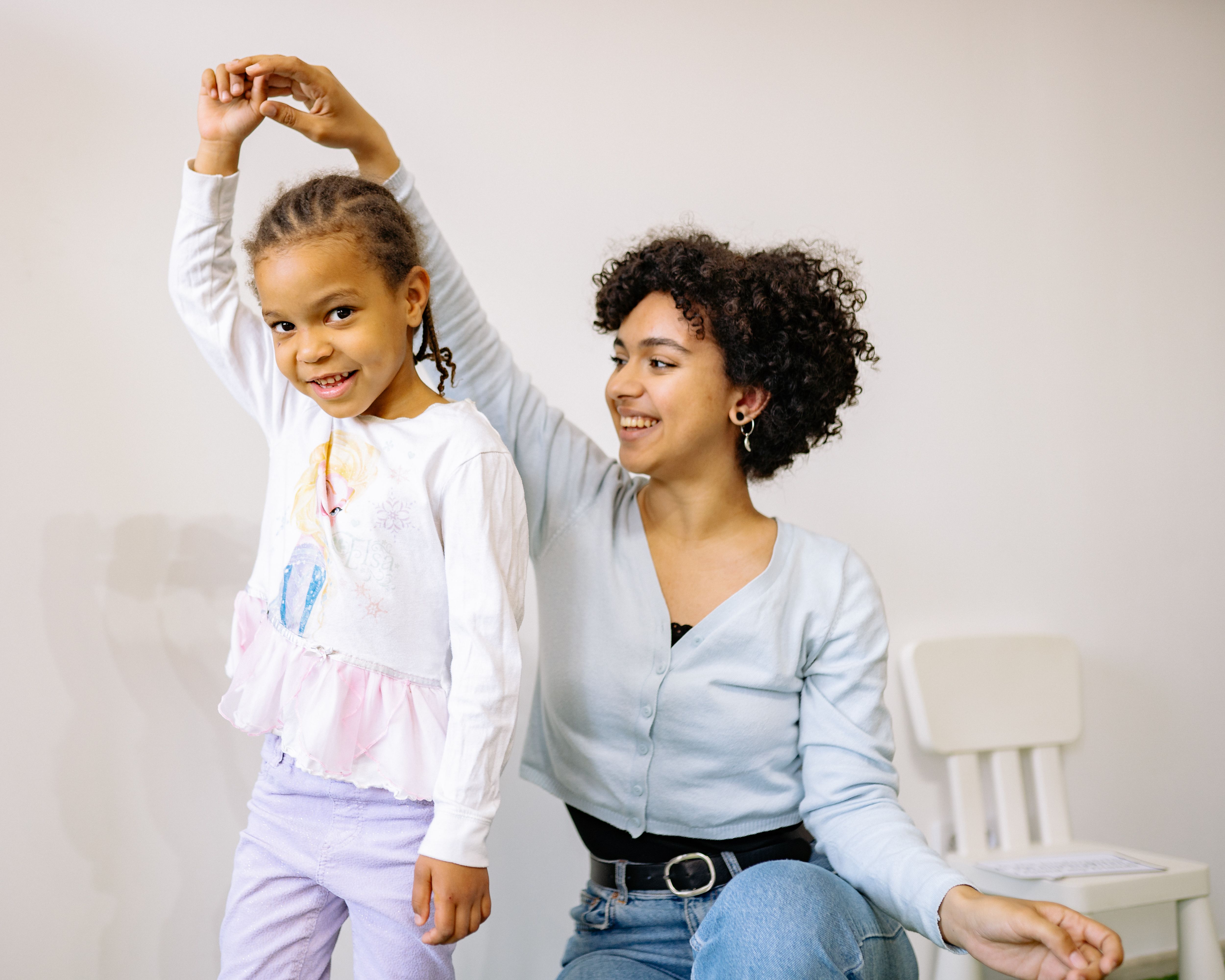 Therapist and young child smiling and playing together